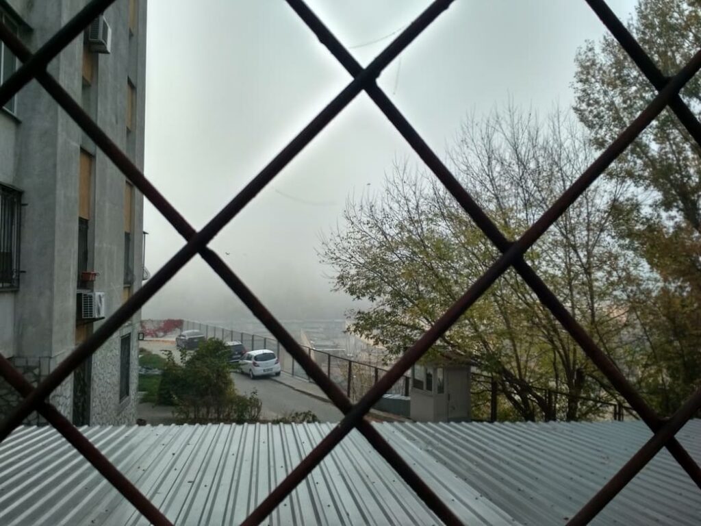 Погляд через сітку у двір багатоповерхового будинку по проспекту Валерія Лобановського.